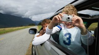 Boy taking photo out of car