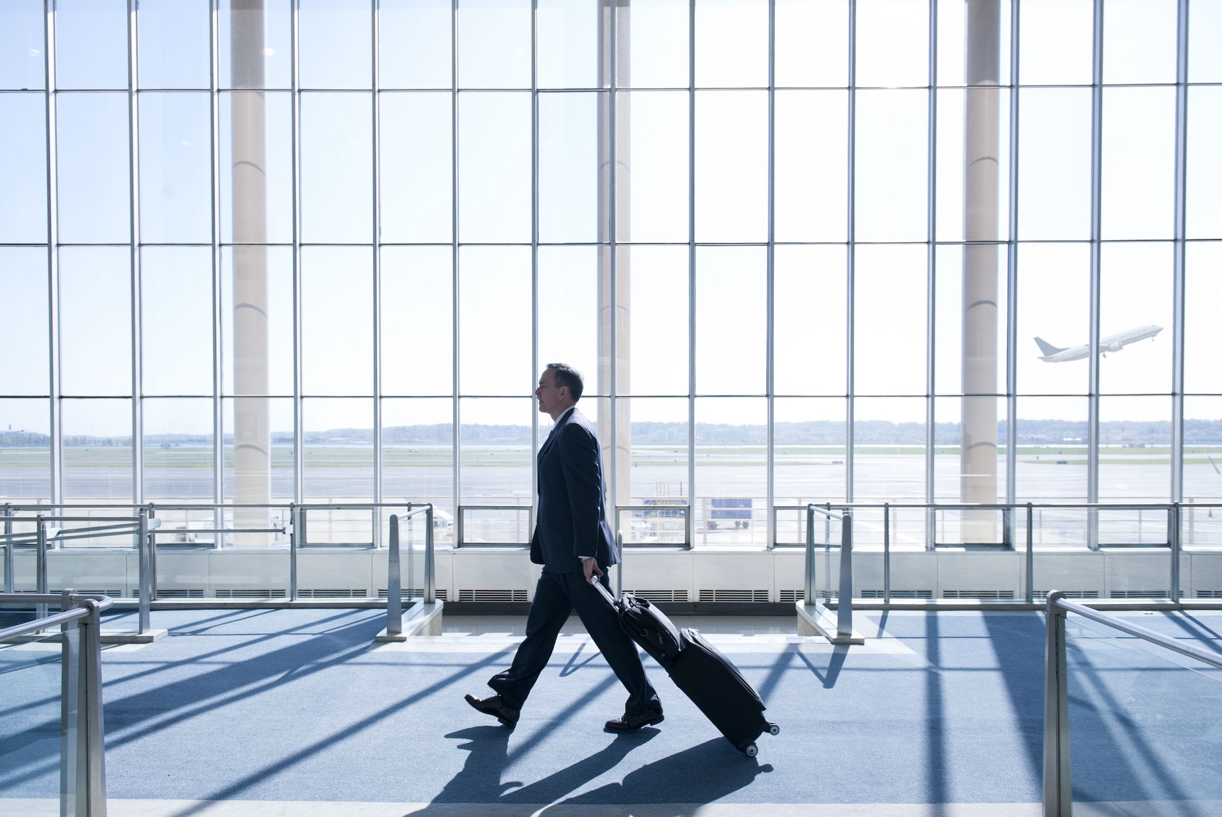 Man with suitcase walking through airport